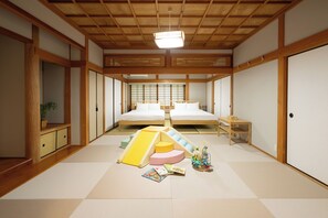 A traditional Japanese-style bedroom with tatami flooring, a low wooden bed, sliding doors, and a ceiling fan. - Kawamoto villa 3466 (Yufu)