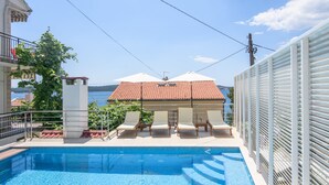 A swimming pool with lounge chairs and a view of the sea. - A3-90m2 apt w shared pool & balcony,next to beach (Trogir)