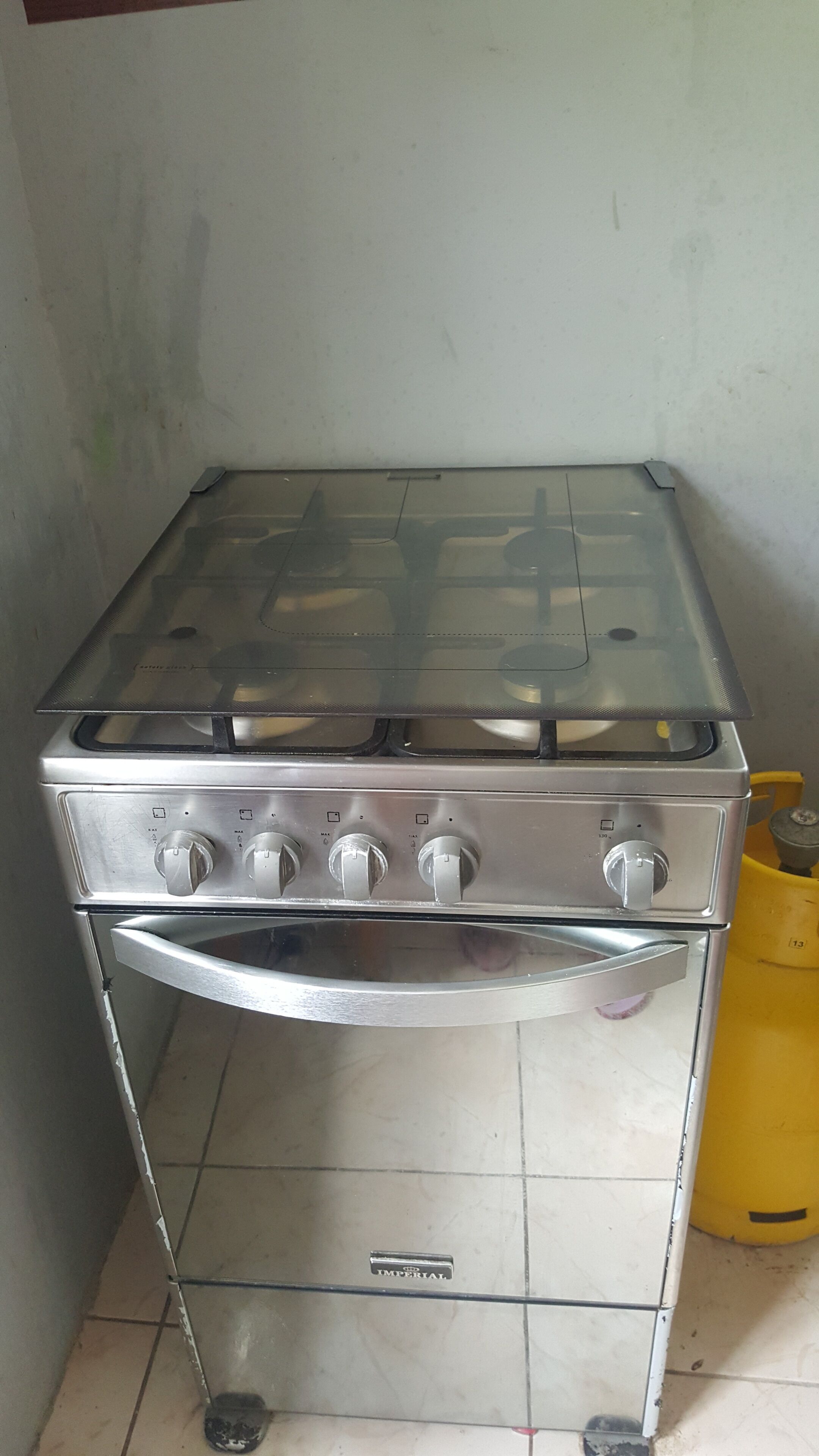 A stainless steel gas stove with four knobs and a built-in oven.