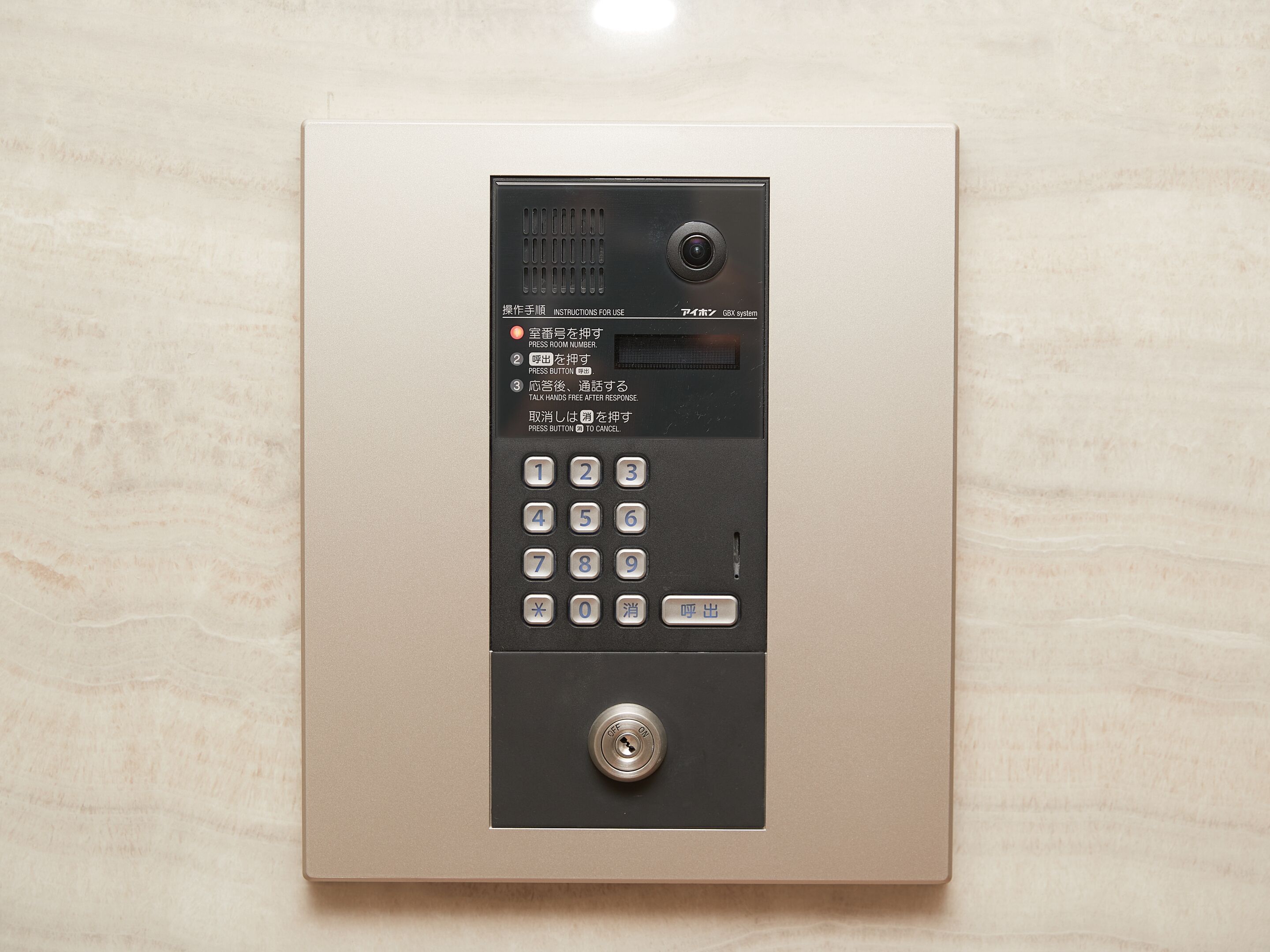 A hotel room's control panel with a numeric keypad, a small screen, and a lock.