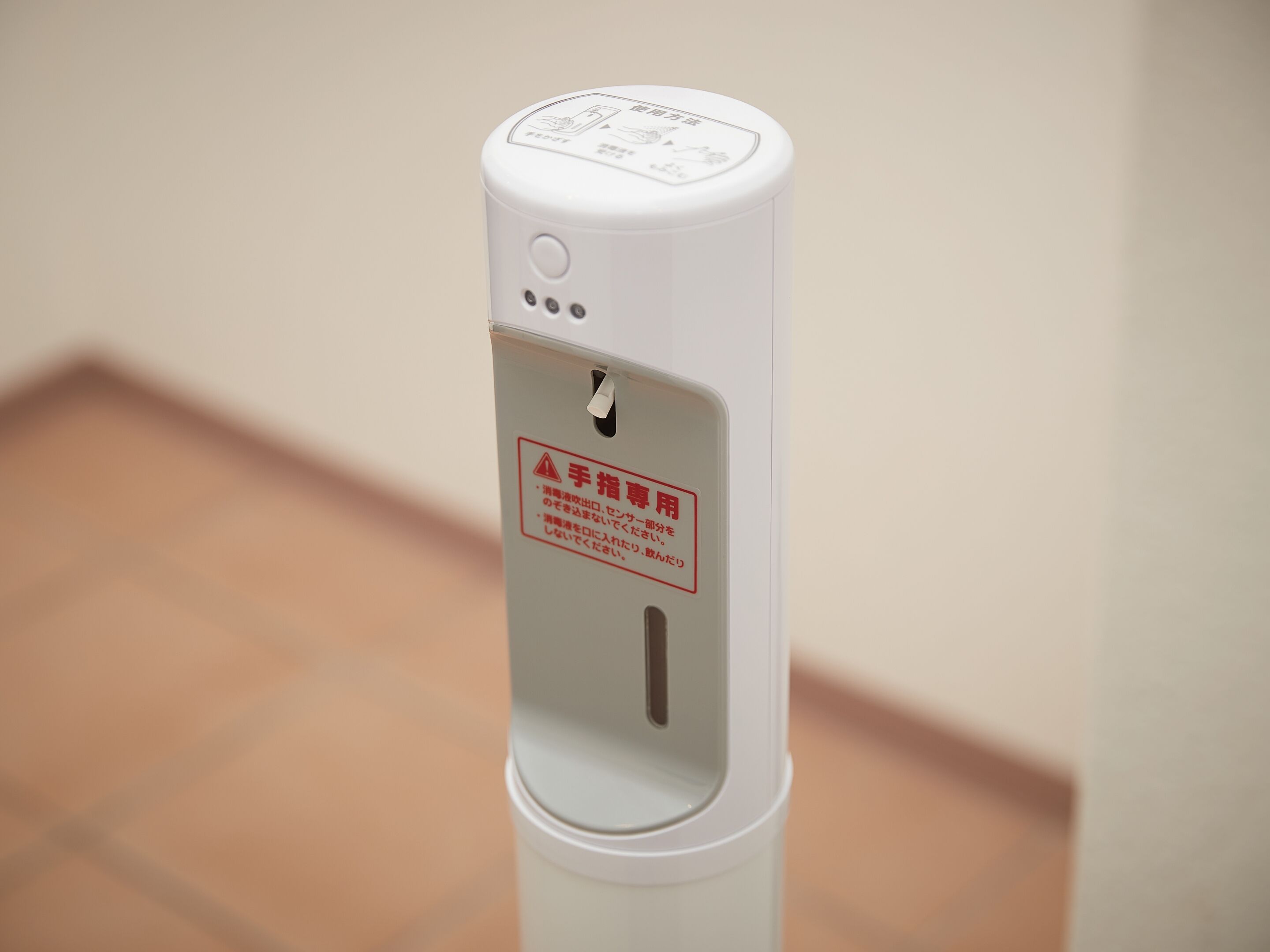A hand sanitizer dispenser with a warning label in a foreign language.