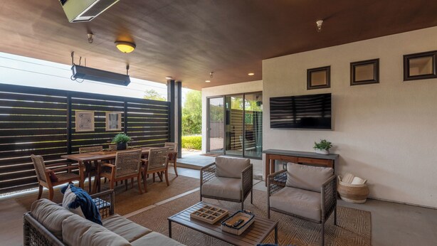 A modern living room with a sofa, armchairs, a coffee table, and a TV mounted on the wall. - Capri Coastal Tuscan Getaway – Ideal for Extended Stays! (Encinitas)