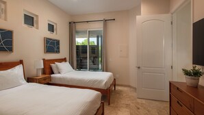 A hotel room with two beds, a sliding glass door to a balcony, a wooden dresser, and artwork on the walls. - Capri Coastal Tuscan Getaway – Ideal for Extended Stays! (Encinitas)