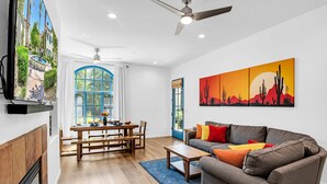 Un salon comprenant un canapé, une table basse et un tableau représentant un paysage désertique.
