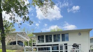 A two-story house with a covered porch and a garage. - Lake of Egypt Cove - Waterfront Home, Kayaks, Pet Friendly (Creal Springs)