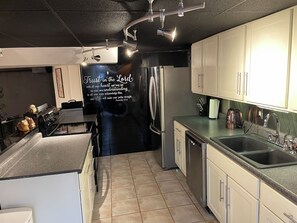 A modern kitchen with stainless steel appliances, a built-in oven, and a large island.