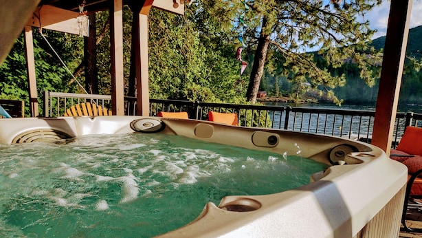 Un jacuzzi con vista a un lago y árboles.