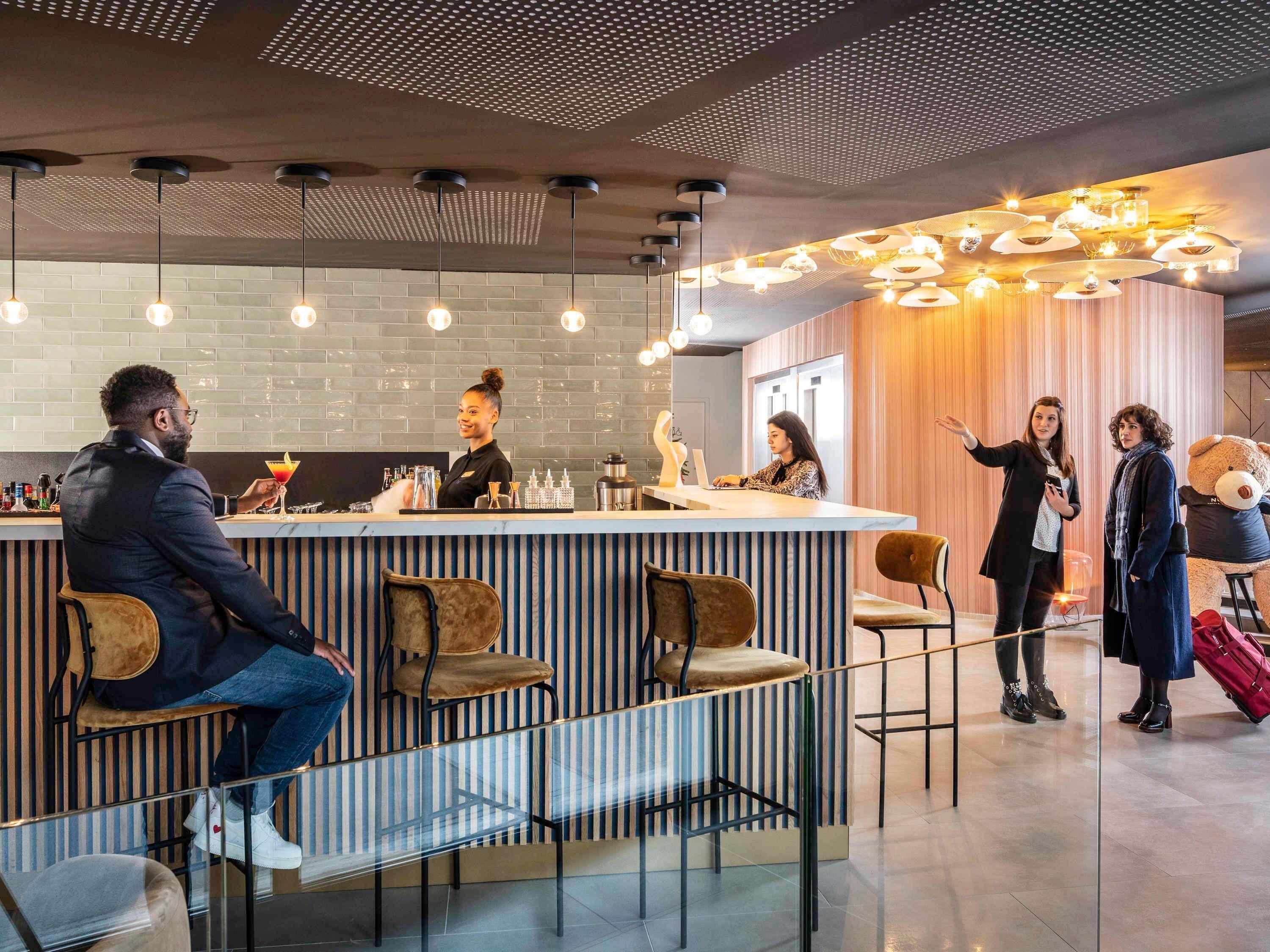 A modern bar area with a bar counter, seating, and a decorative ceiling.