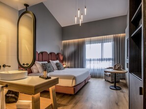 A modern hotel room with a large bed, bedside table, mirror, and a small round table with a chair. - Mercure Lugo Centro (Lugo)