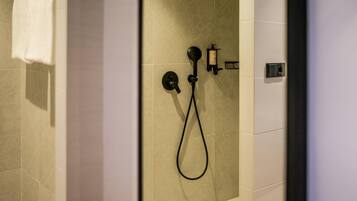 Un baño moderno con ducha, toallero y dispensador de jabón.
