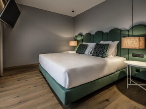 A modern hotel room with a large bed, a small round table, and a television mounted on the wall. - Mercure Lugo Centro (Lugo)