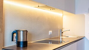 Een moderne keuken met een roestvrijstalen waterkoker, een spoelbak en een aanrecht.