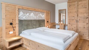 Een houten bed met hoofdeinde, een nachtkastje en een garderobe.