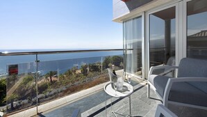 A balcony with a glass table, two chairs, and a view of the sea. - Villa View Grand with Sea View, Pool & Wi-Fi (Santa Ursula)