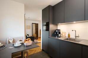 A modern kitchen with a built-in oven, a coffee machine, and a sink.