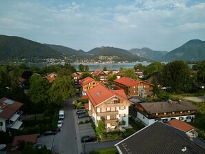 Un barrio residencial con casas, una calle y un lago al fondo.