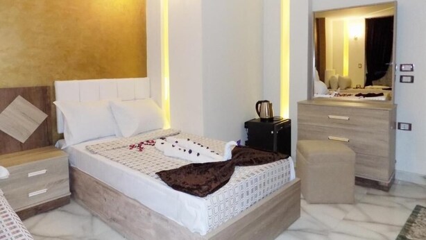 Une chambre à coucher moderne, avec un lit, des tables de chevet, une commode et un miroir.