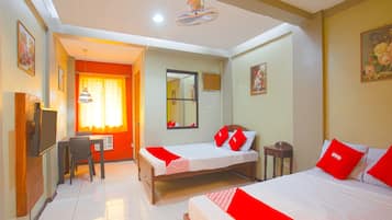 A hotel room with two beds, a desk, and a chair.
