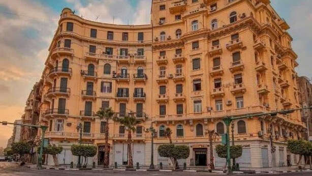 A large, multi-story hotel with a curved facade, numerous balconies, and a spacious entrance area. - Grand Talat Harb Plaza (Cairo)