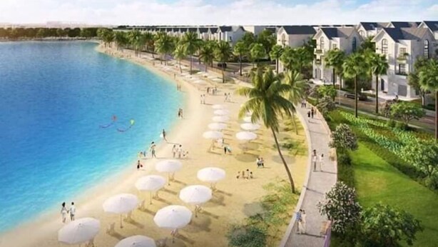 A beachfront hotel with rows of villas, a sandy beach with umbrellas, and palm trees. - Bom Homes- Vinhomes Ocean Park  (Hanoi)