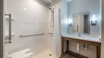 A modern bathroom with a walk-in shower, a white toilet, a sink with a mirror, and a towel rack.