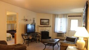 Ein Wohnzimmer mit Kamin, Fernseher und einer Couch.