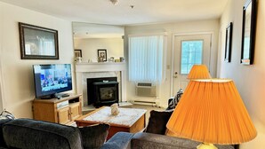 A living room with a fireplace, television, and a lamp. - Cozy vacation condo sleeps 6. #201 (Lincoln)