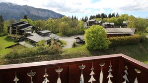 A mountainous resort with traditional wooden buildings, a central courtyard, and a view of the surrounding landscape. - Spacious 4-room apartment well equipped with Wi-Fi and parking, at the foot of the ski bus (Les Carroz d'Arâches)