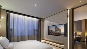 A modern hotel room with a large bed, a TV mounted on the wall, and a view of the cityscape through the window. - Novotel Tianjin Drum Tower (Tianjin)