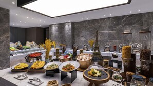 A buffet with various food items and a decorative Eiffel Tower model. - Novotel Tianjin Drum Tower (Tianjin)