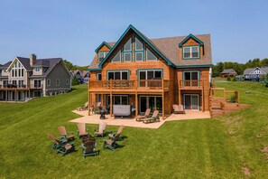 A large wooden house with a balcony, a deck, and outdoor seating. - Lakefront Lodge w/ Hot Tubs, Games & More (Swanton)