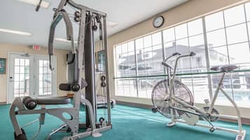 A gym with exercise equipment, a bicycle, and large windows.