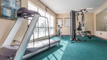A gym with treadmills, weight machines, and exercise mats.