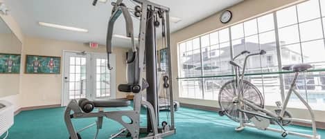 A gym with exercise equipment, a bicycle, and a large window with a view.