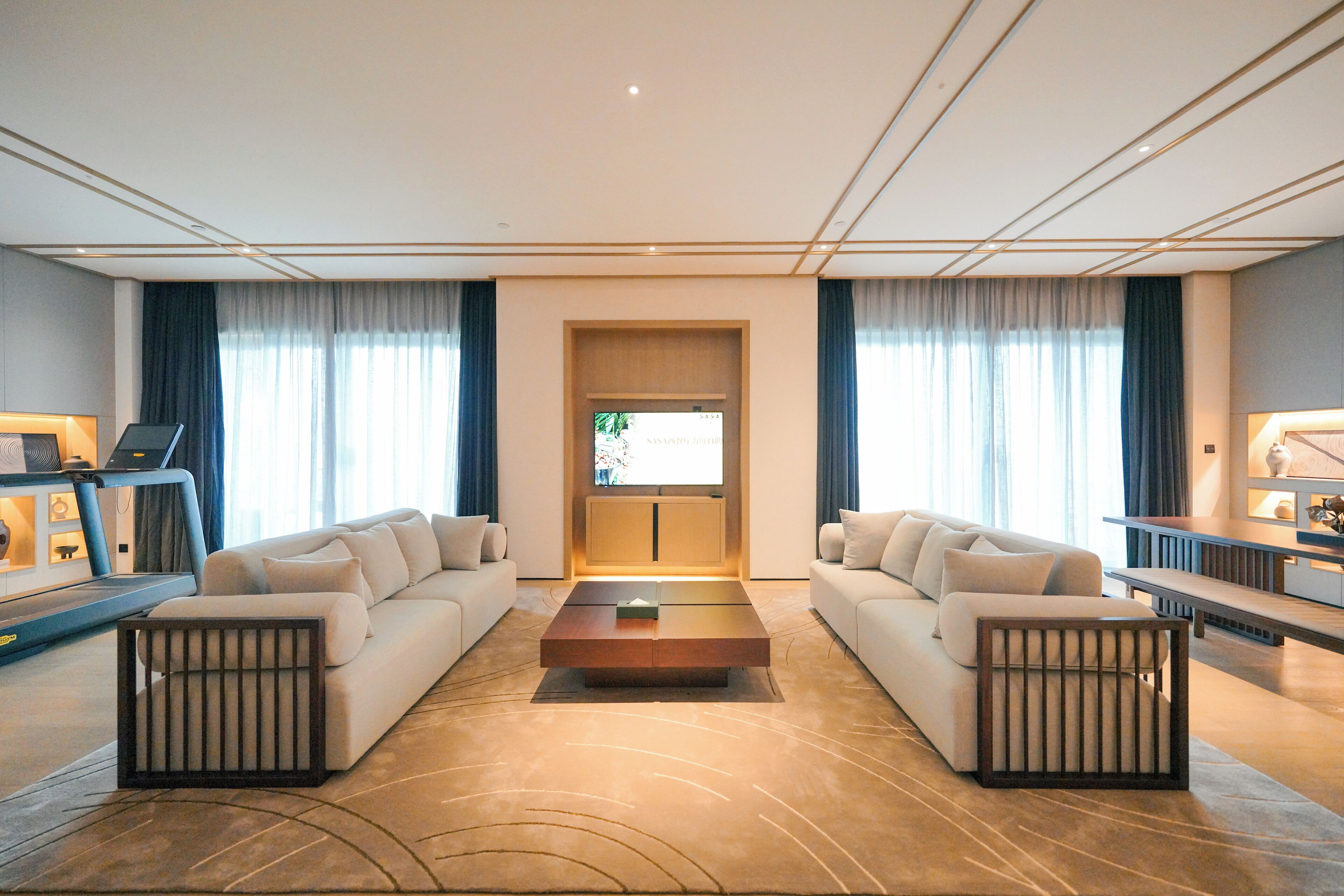Una sala de estar moderna con un conjunto de sofá, una mesa de centro y una pantalla de televisión.