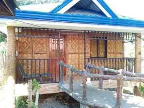 A building with a wooden facade, a metal gate, and a small bridge leading to the entrance. - Reddoorz Near Gaisano Grand Cordova (Cordova)