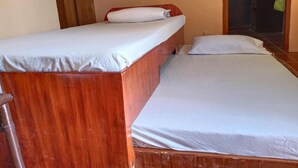 A single bed with a wooden frame and white bedding in a room with beige walls. - Reddoorz Near Gaisano Grand Cordova (Cordova)