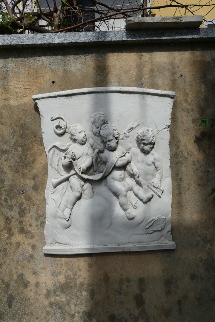 A relief sculpture of three cherubs on a wall.