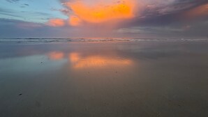 A beach with a calm sea, clear sky, and a sunset. - Sand Dollar 2-201 Direct Oceanfront Corner Unit (Saint Augustine)