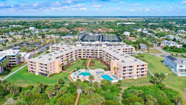 A large, multi-story hotel with a central courtyard and swimming pool.