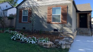 A two-story house with a gabled roof, wooden shutters, and a stone foundation. - Excellent location right across the street from the Expo Center! – Sleeps 8 (Tulsa)