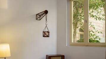 Ein Holztisch mit einem Stuhl, einer Lampe, einem Radio und einer hängenden Laterne.
