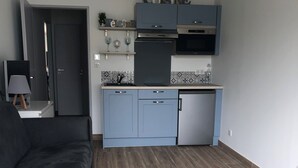 Una cucina moderna con mobili blu, forno integrato e microonde.