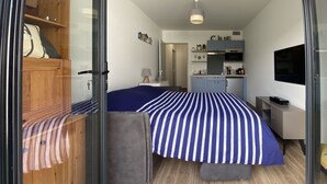 Una camera da letto compatta con un letto, comodino e armadio.