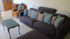 A living room with a brown sofa, a wooden cabinet, and a green table. - Il Paradiso Vista Mare (Levanto)