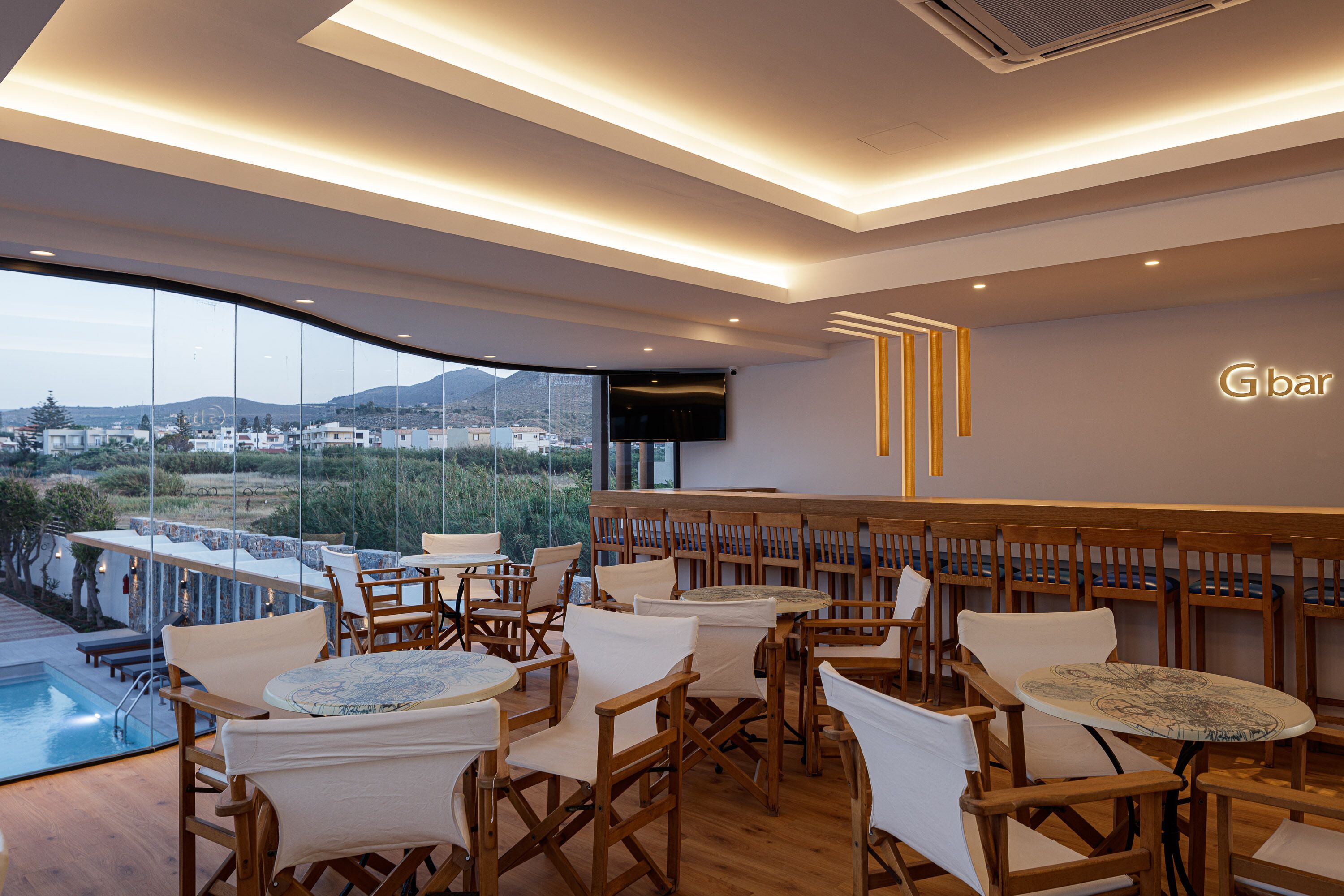 A modern bar area with wooden furniture and a view of a mountainous landscape.
