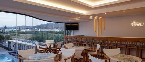 Un bar moderno con mobiliario de madera y vistas a un paisaje montañoso.