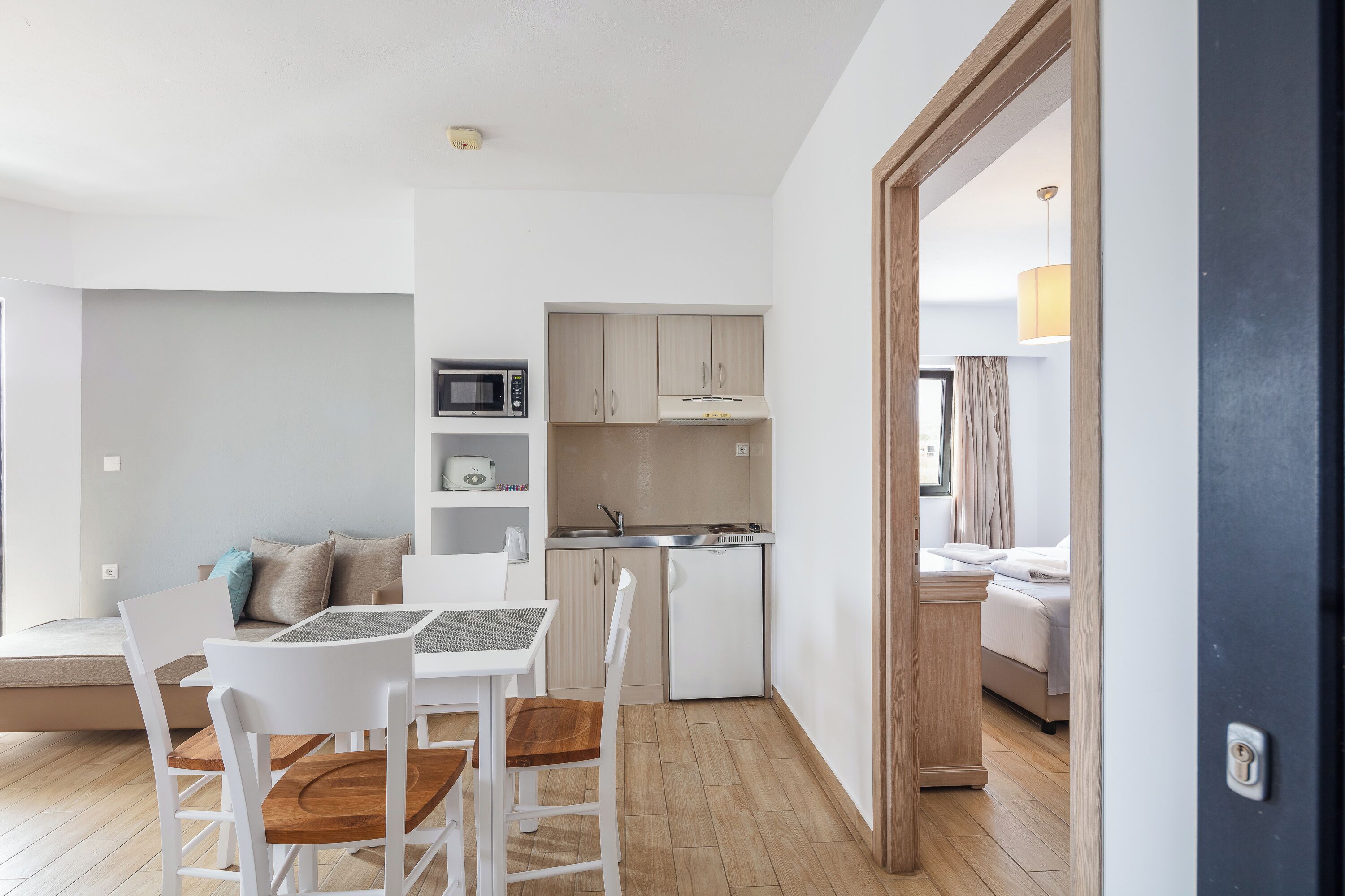A compact living space with a dining area, kitchenette, and a bedroom.