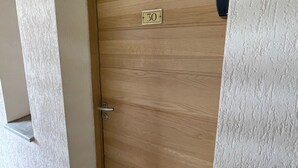 Una puerta de madera con una placa numerada con el número 30 y un tirador de metal.