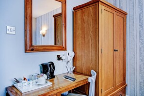 Escritorio, tabla de planchar con plancha y ropa de cama 